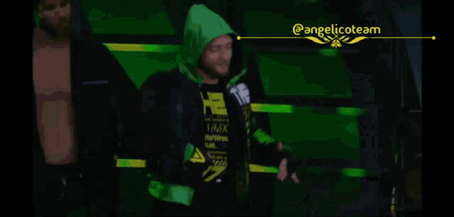 a person in a green and black outfit is standing in a wrestling ring