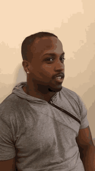 a man in a grey shirt with a black zipper on the side