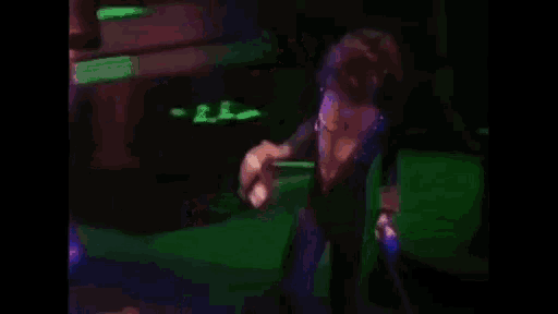 a woman in a black dress is singing into a microphone on a stage .