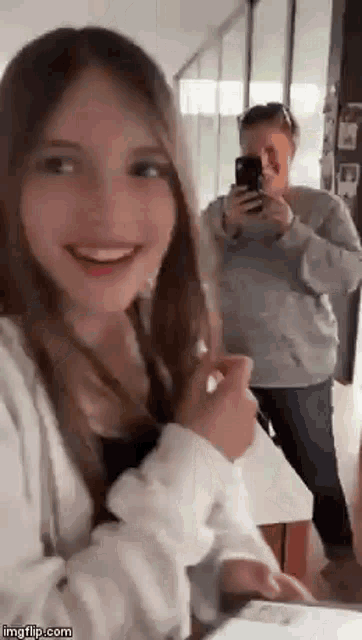 a woman is taking a picture of a young girl while another woman looks on .