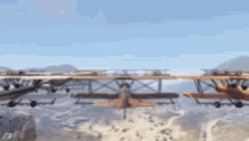 a group of planes are flying over a desert