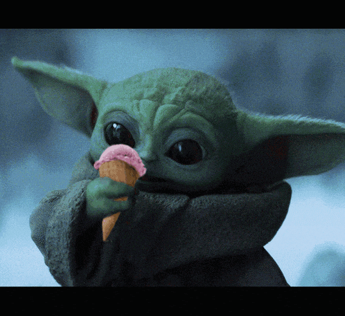 a baby yoda holding an ice cream cone in his hand