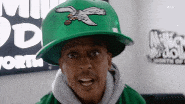 a man wearing a green hat with an eagle on it looks surprised