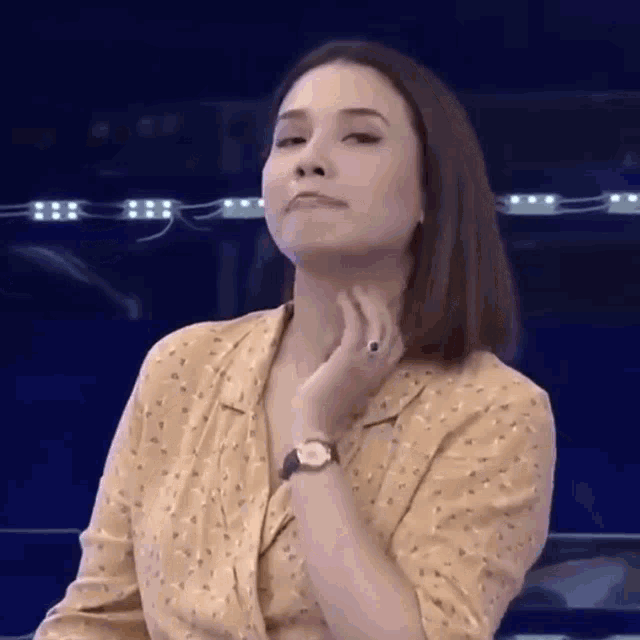 a woman wearing a watch is making a funny face .