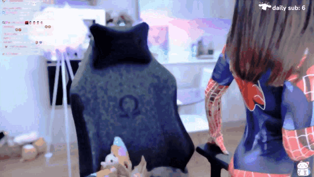 a woman in a spiderman costume is sitting in a chair with a daily sub of 6