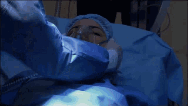a person in a surgical gown is getting an oxygen mask on their face