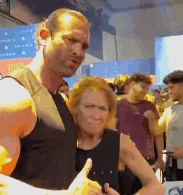 a man is giving a thumbs up to a woman in a crowd of people