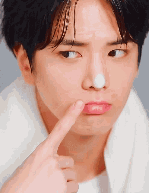 a close up of a person 's face with their finger on their nose