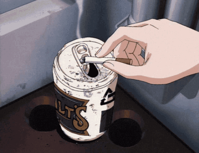 a hand is putting a cigarette into a can that says lts