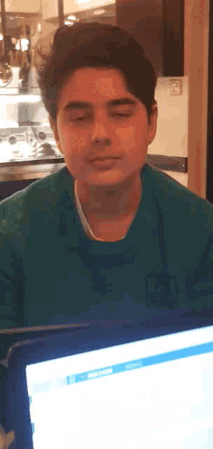 a young man wearing a green shirt with the letter f on it