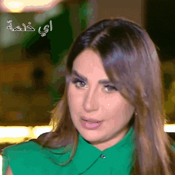 a woman in a green shirt with arabic writing on the bottom right