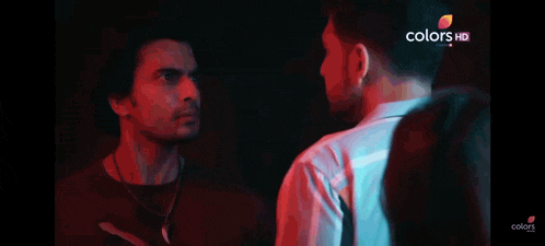 two men are standing next to each other in a dark room and the words colors hd are on the bottom right