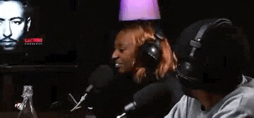 a man and a woman are sitting in front of a microphone in a room .