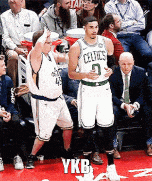 a basketball player with the number 7 on his jersey is standing next to another player