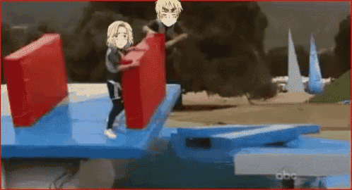 a man and a woman are holding red blocks while standing on a blue platform .