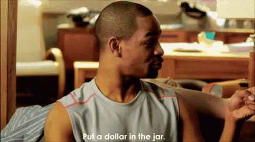a man is sitting on a couch talking about putting a dollar in a jar