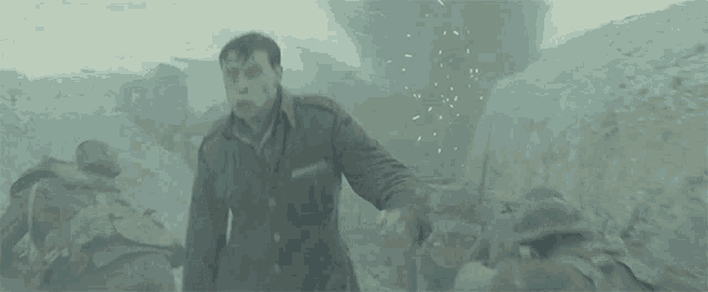 a man in a military uniform is standing in a trench .