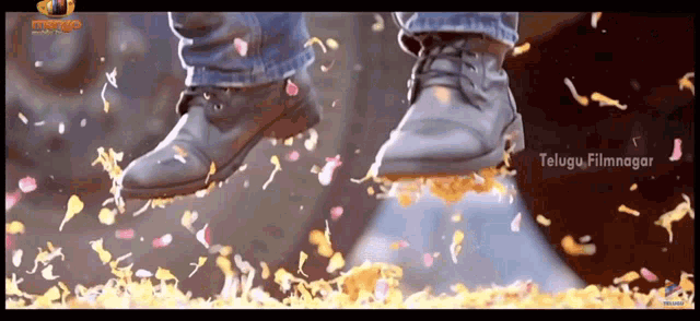 a person 's foot is standing on a pile of confetti with telugu filmnagar written on the bottom