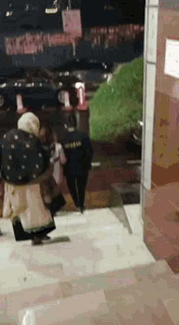 a group of people are walking down a set of stairs in a parking lot .