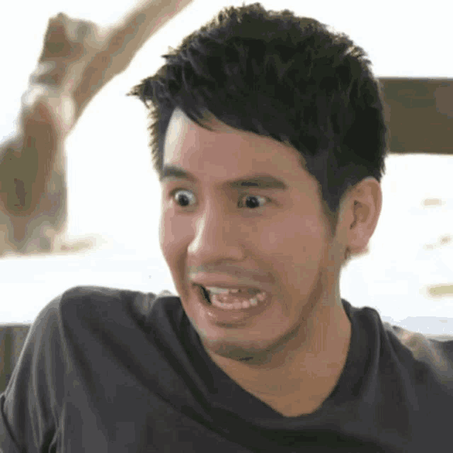 a close up of a man making a funny face with his mouth open