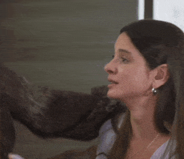 a woman wearing hoop earrings looks at another woman