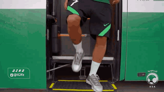 a man wearing green shorts with the number 7 on the back