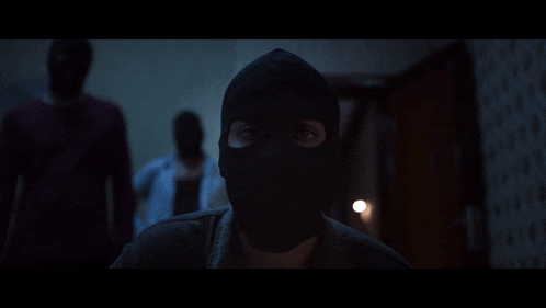 a man wearing a black mask is looking at the camera