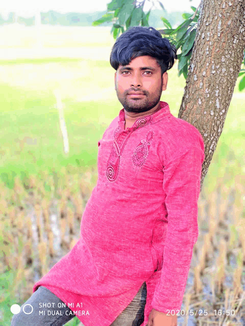 a man leaning against a tree with a shot on mi a1 camera