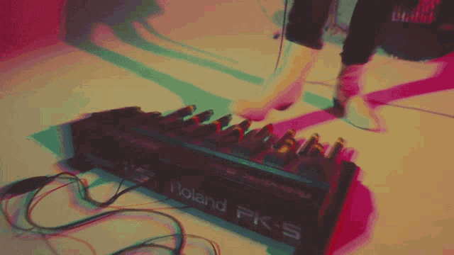 a person 's foot is on a roland pk-5 keyboard