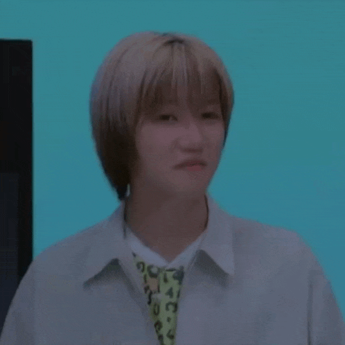 a young woman with short blonde hair is making a funny face while wearing a leopard print shirt .