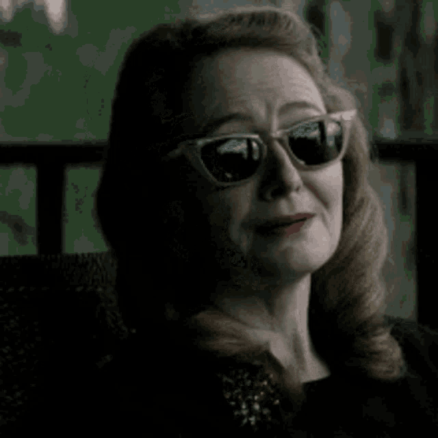 a woman wearing sunglasses says praise in the corner of her face