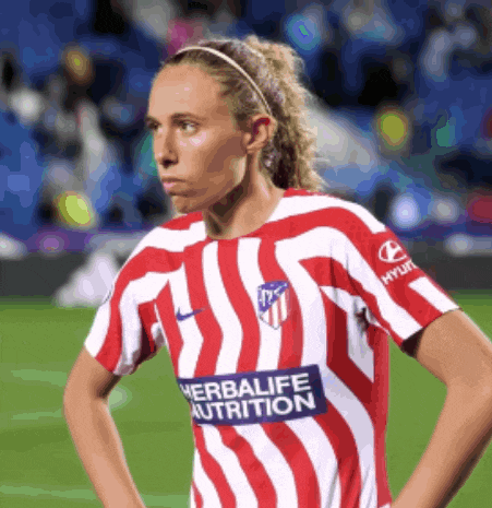 a woman wearing a red and white striped shirt with herbalife nutrition on the sleeve