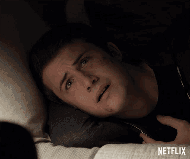 a man is laying on a bed with a netflix logo in the corner