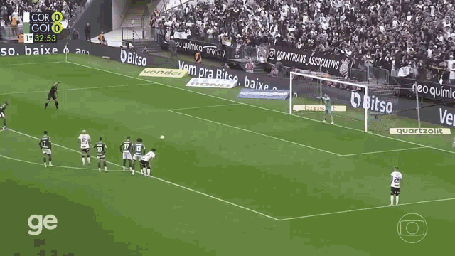 a soccer player celebrates a goal in front of a scoreboard that says cor 0 go 0