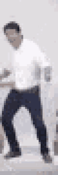 a man in a white shirt and blue jeans is standing in front of a white wall .