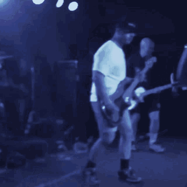 a man in a white shirt playing a guitar