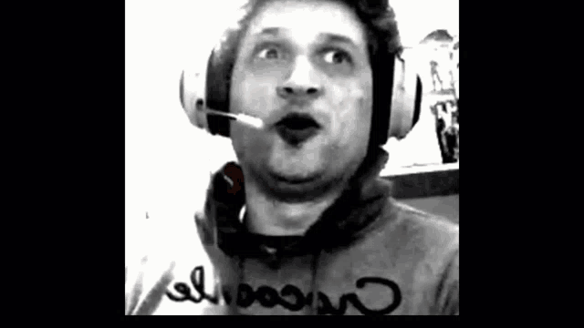 a man wearing headphones and a microphone making a funny face