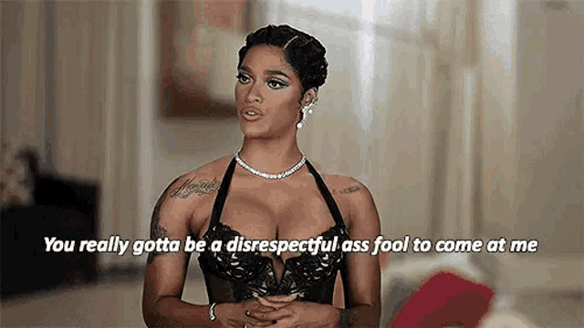 a woman in a black bra and a necklace is talking to someone .