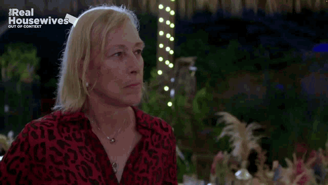 a woman in a red and black leopard print shirt is on the real housewives show