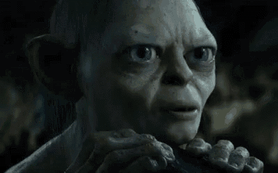 a close up of a gollum from the lord of the rings holding something in his hands .