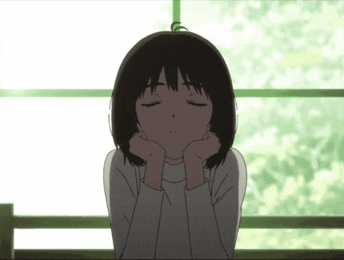 a girl with her eyes closed has her hands on her chin