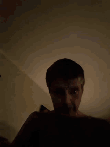 a man 's face is visible in the dark