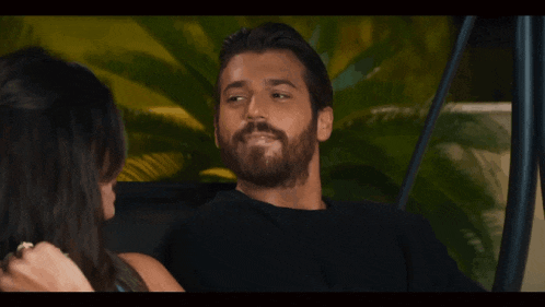 a man with a beard is laughing with a woman