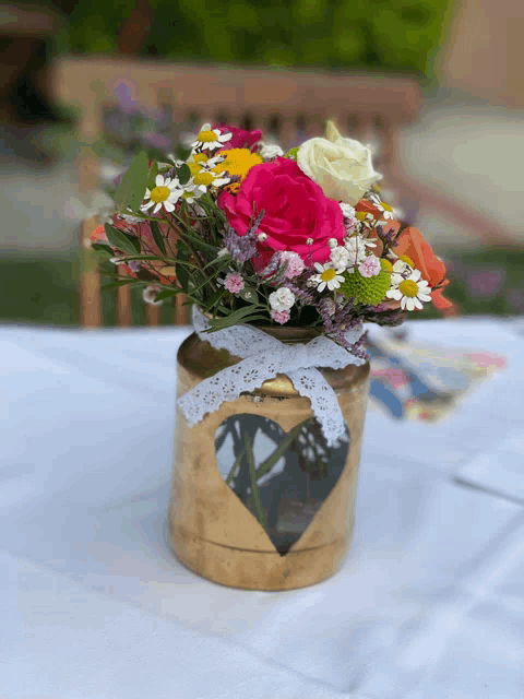 a vase with flowers in it has a heart shaped hole in it