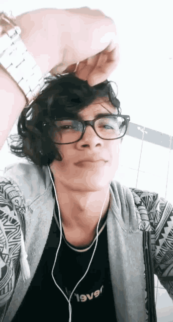 a young man wearing glasses and a shirt that says 19v9r takes a selfie