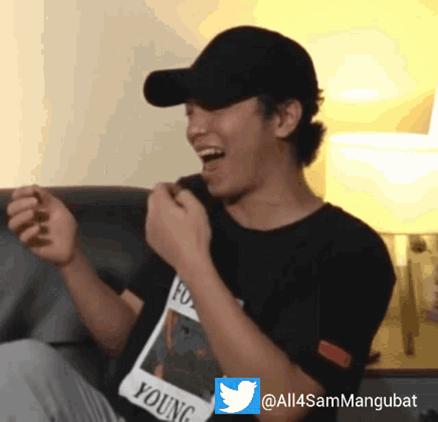 a man wearing a black shirt that says young is laughing
