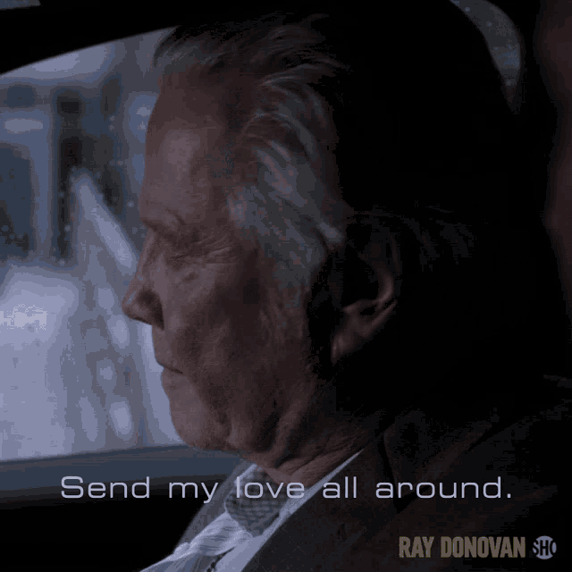 a man in a suit is sitting in a car with the words send my love all around