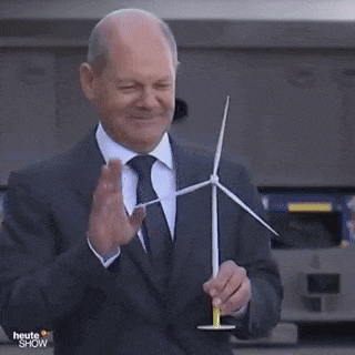 a man in a suit and tie is holding a windmill in his hands .