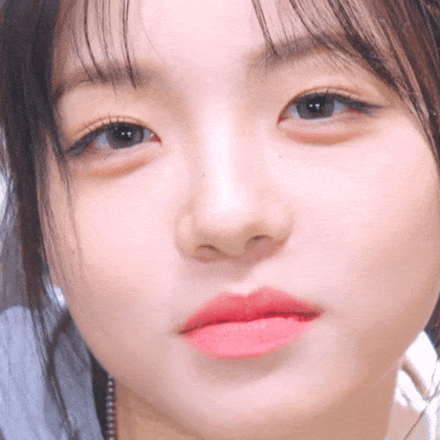 a close up of a woman 's face with red lipstick on her lips
