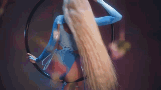a woman in a blue and white costume is holding a hula hoop